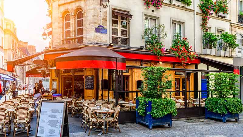 Cozy street with tables of cafe in Paris, France. Architecture and landmark of Paris. Cozy Paris cityscape.